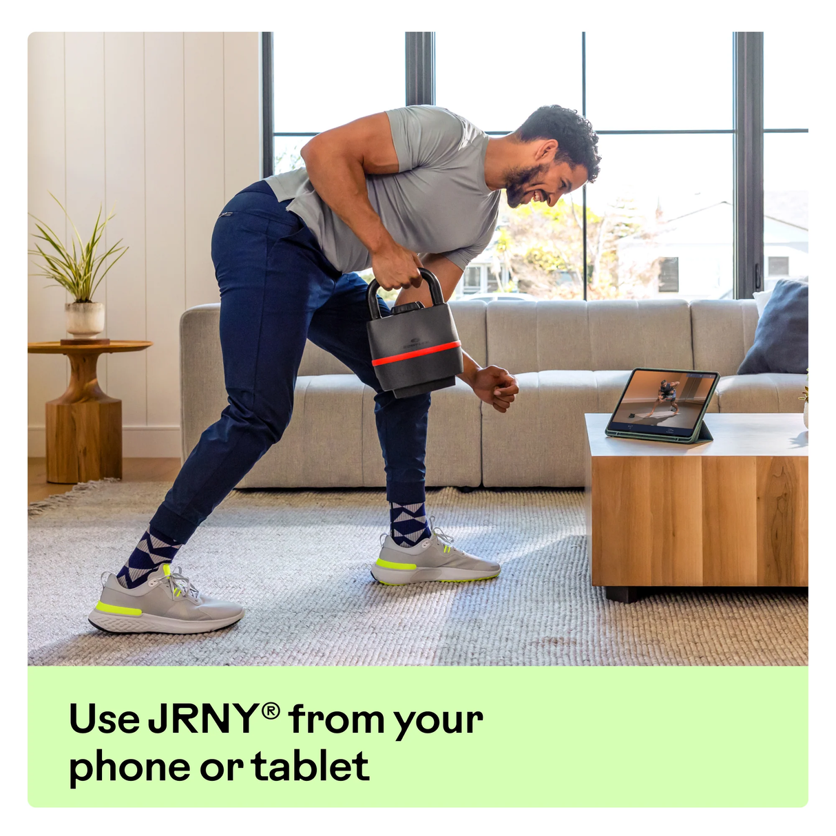 BowFlex 840 Kettlebell in use by man in his living room with Tablet 