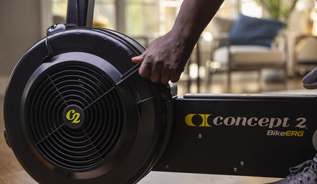 Concept 2 Bike Erg, close up of adjustable damper being adjusted by man.